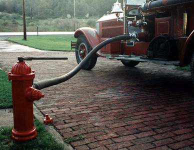 Photo of early Darling hydrant connected to 1929 American LaFrance pumper